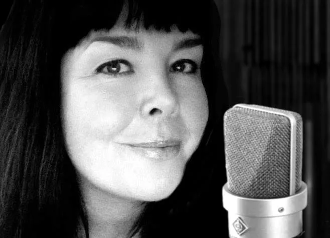 Een professionele studiomicrofoon met popfilter in een geluidsstudio met akoestische panelen.